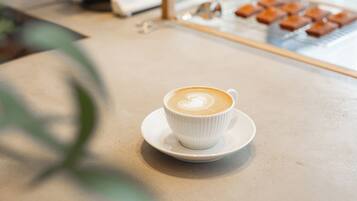A cup of coffee on a saucer on a table.