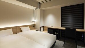 Ein modernes Hotelzimmer mit einem großen Bett, einem Schreibtisch und einem Stuhl.