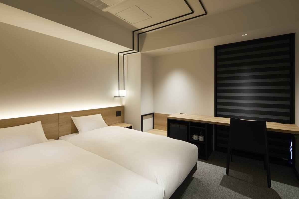 Een moderne hotelkamer met een groot bed, een bureau en een stoel.