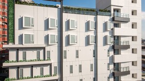 A modern multi-story building with a flat facade, large windows, and a rooftop garden. - Hotel Ramble (Taichung)