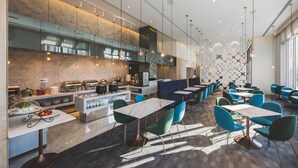 A modern restaurant with marble countertops, blue chairs, and a central island with food displays. - Hotel Ramble (Taichung)