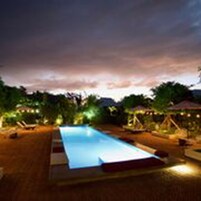Una piscina al aire libre, sillones reclinables de piscina