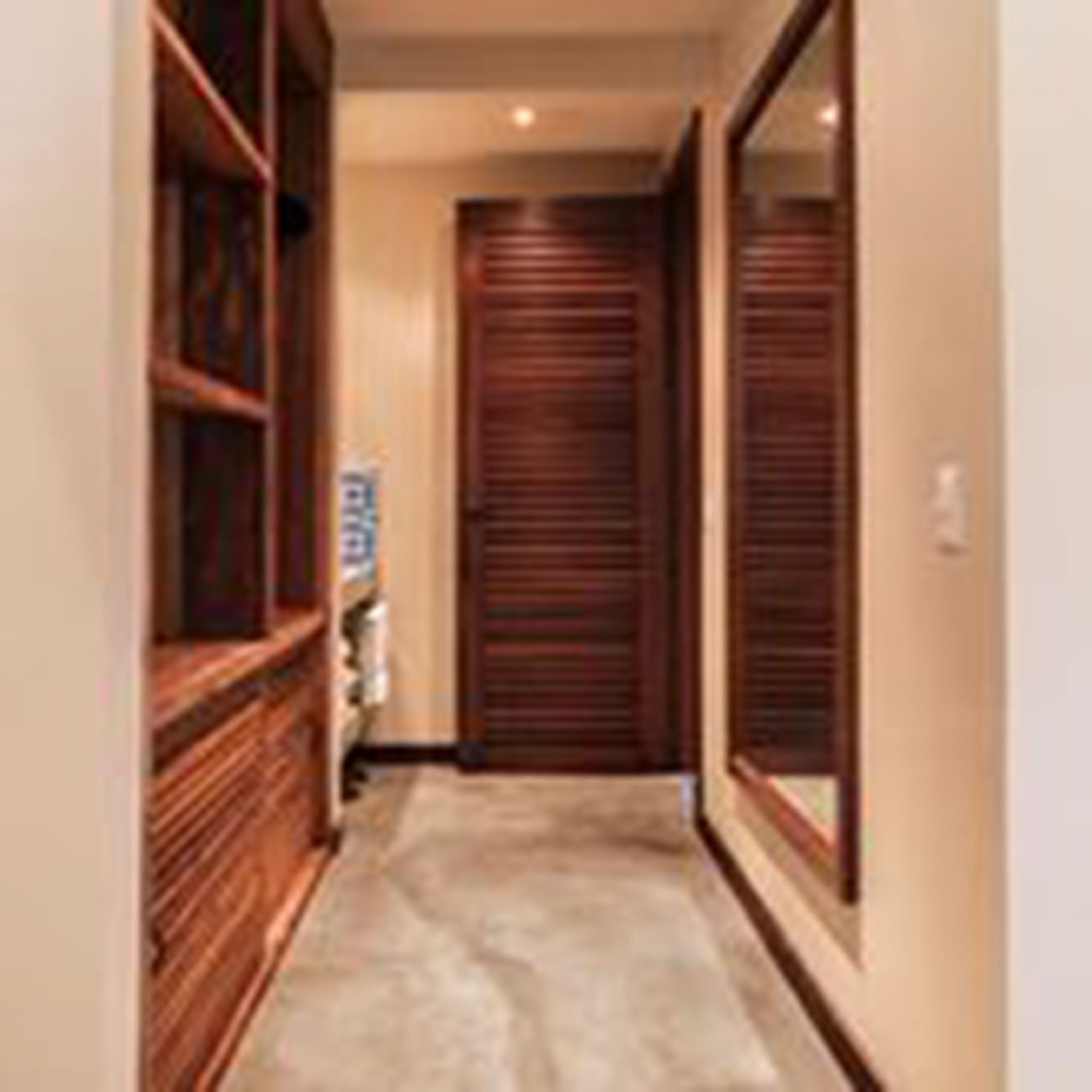 Un pasillo con puertas de madera y piso alfombrado.