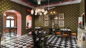 A grand room with a checkered floor, ornate furniture, and a balcony with intricate railings. - Nivah (Moradabad)