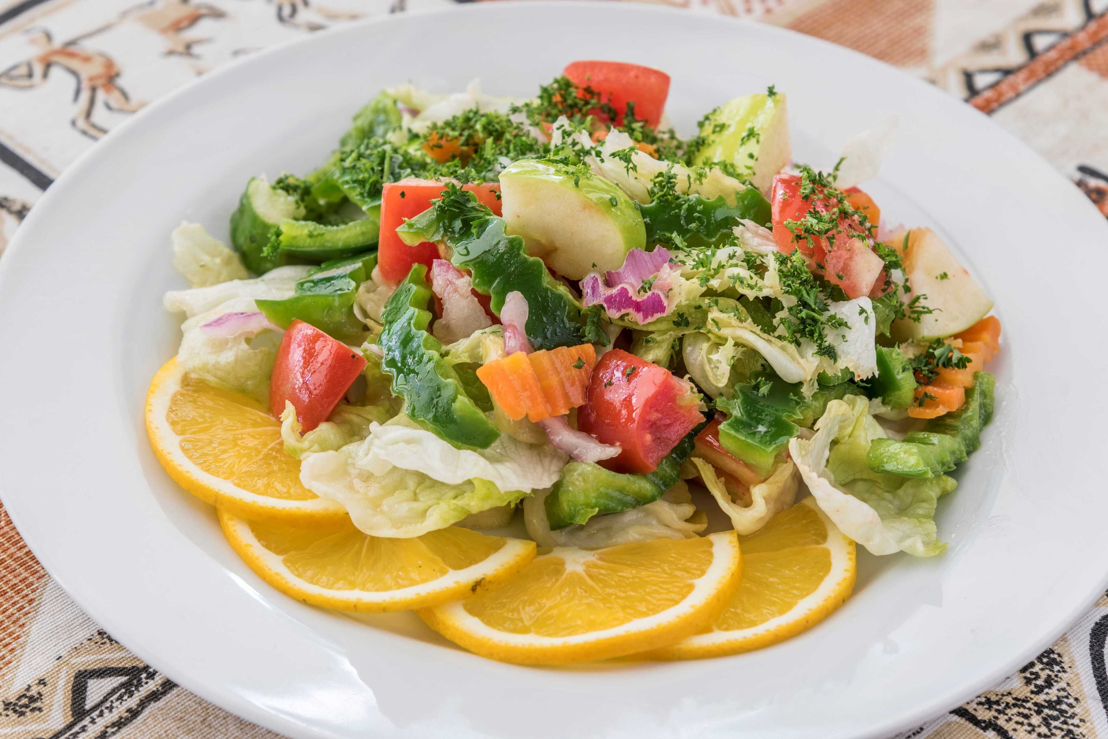 Ensalada mixta de verduras con rodajas de limón.