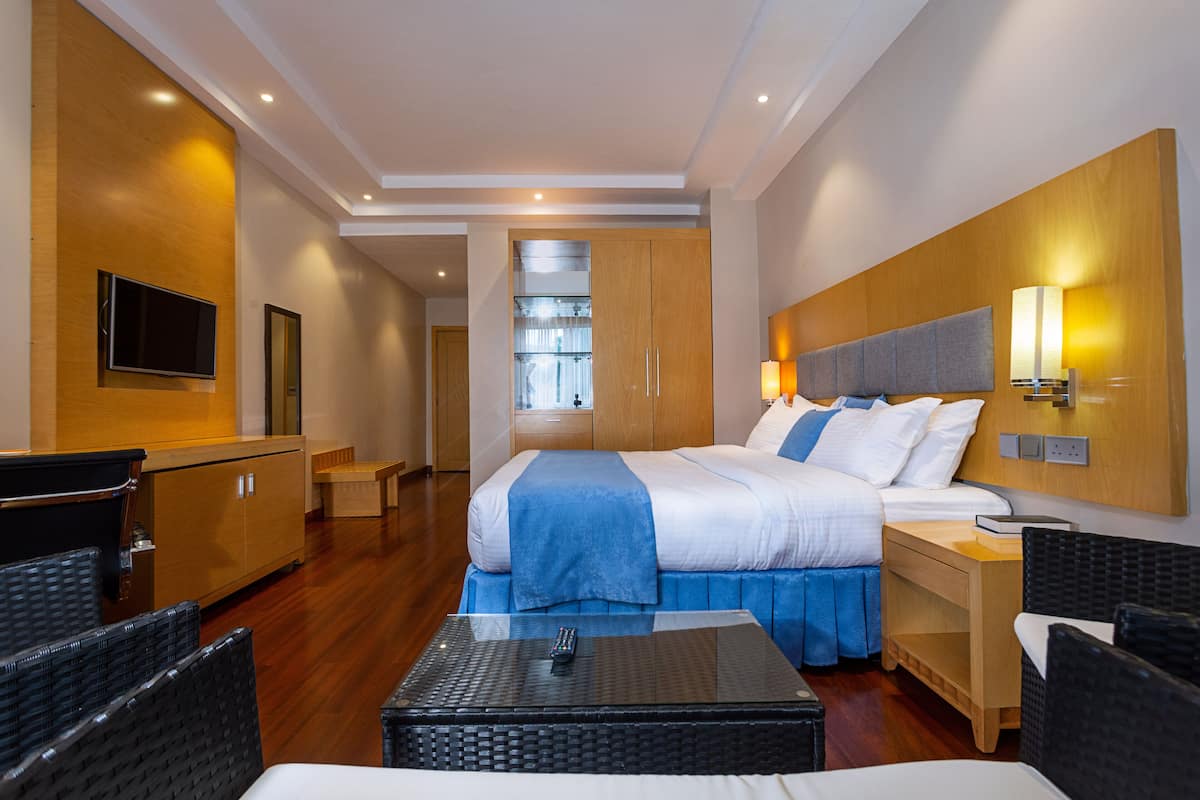 A hotel room with a bed, a TV, a desk, and a chair.