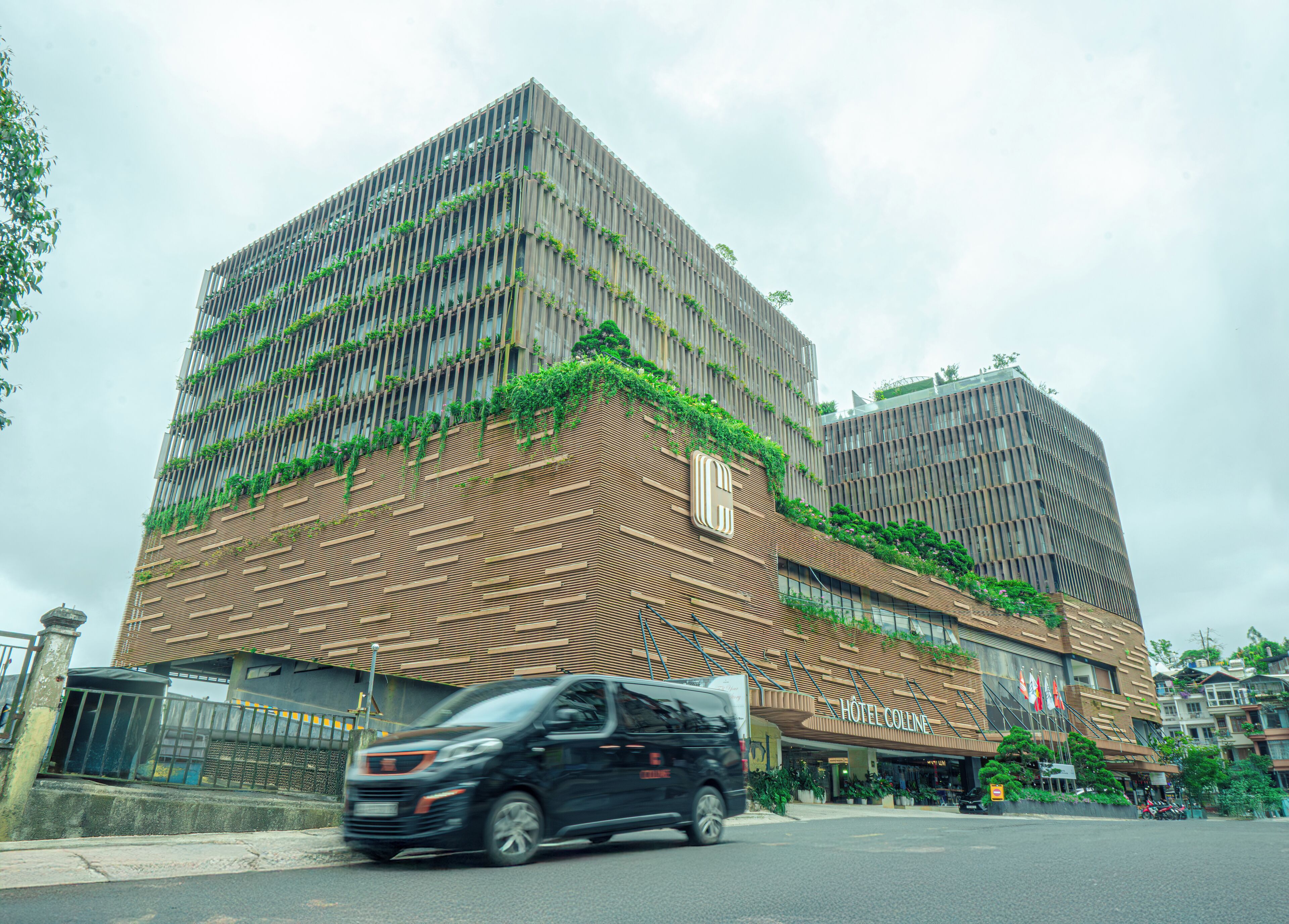 A modern hotel with a unique facade featuring vertical gardens and a patterned design.