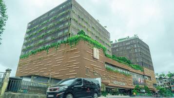 A modern hotel with a unique facade featuring vertical gardens and a patterned design.
