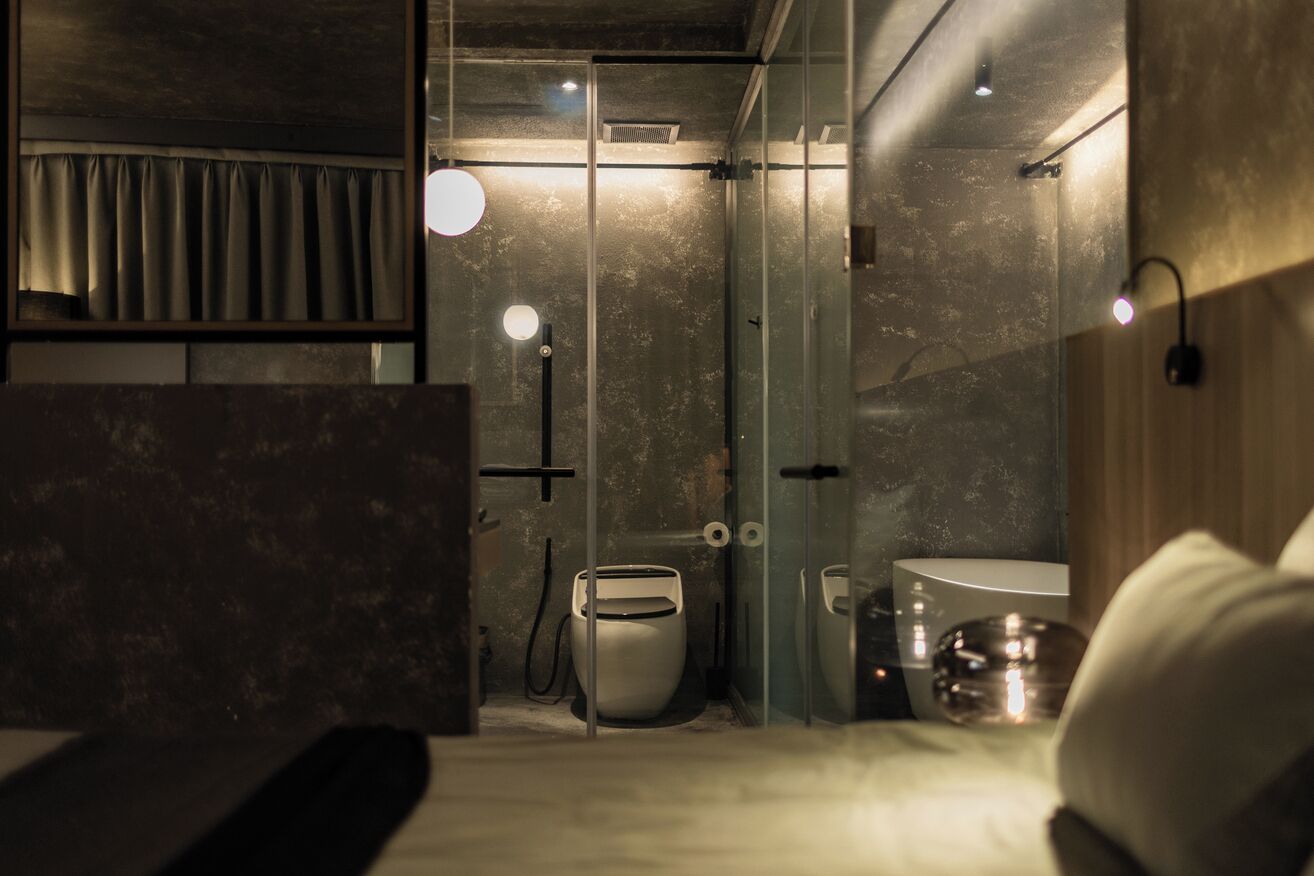 A modern bathroom with a glass shower enclosure, a toilet, and a sink.