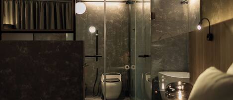 A modern bathroom with a glass shower enclosure, a toilet, and a sink.