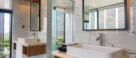 A modern bathroom with a large bathtub, two sinks, and a large mirror.