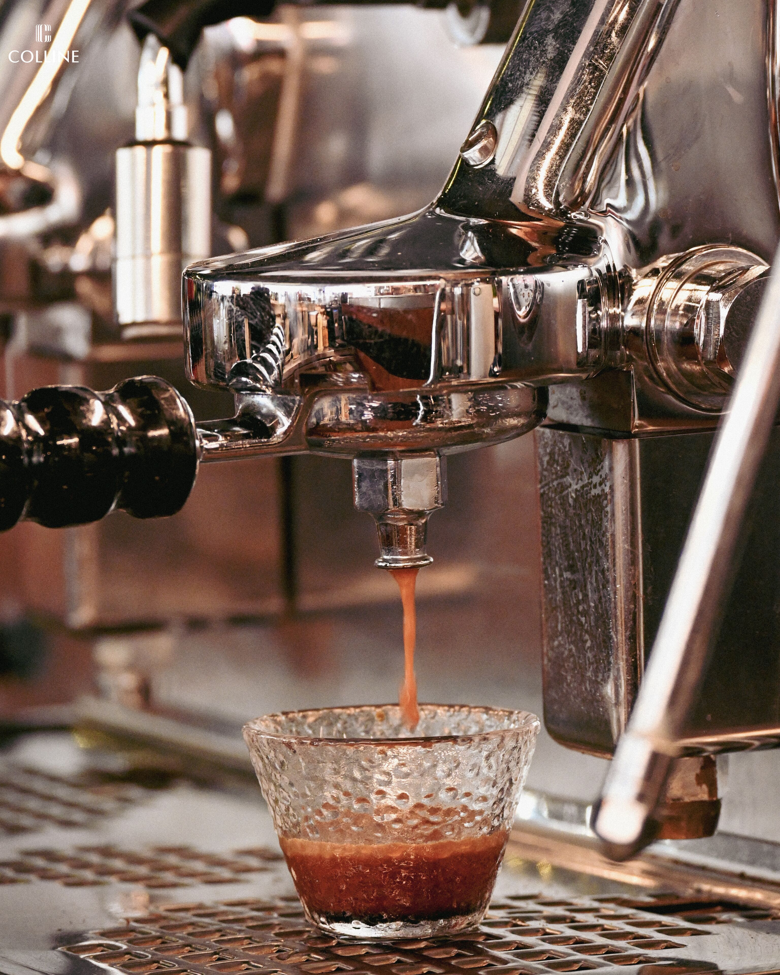 A coffee machine dispensing espresso into a glass cup.