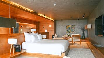 Una habitación de hotel moderna con una cama grande, detalles de madera, un televisor de pantalla plana y un comedor.