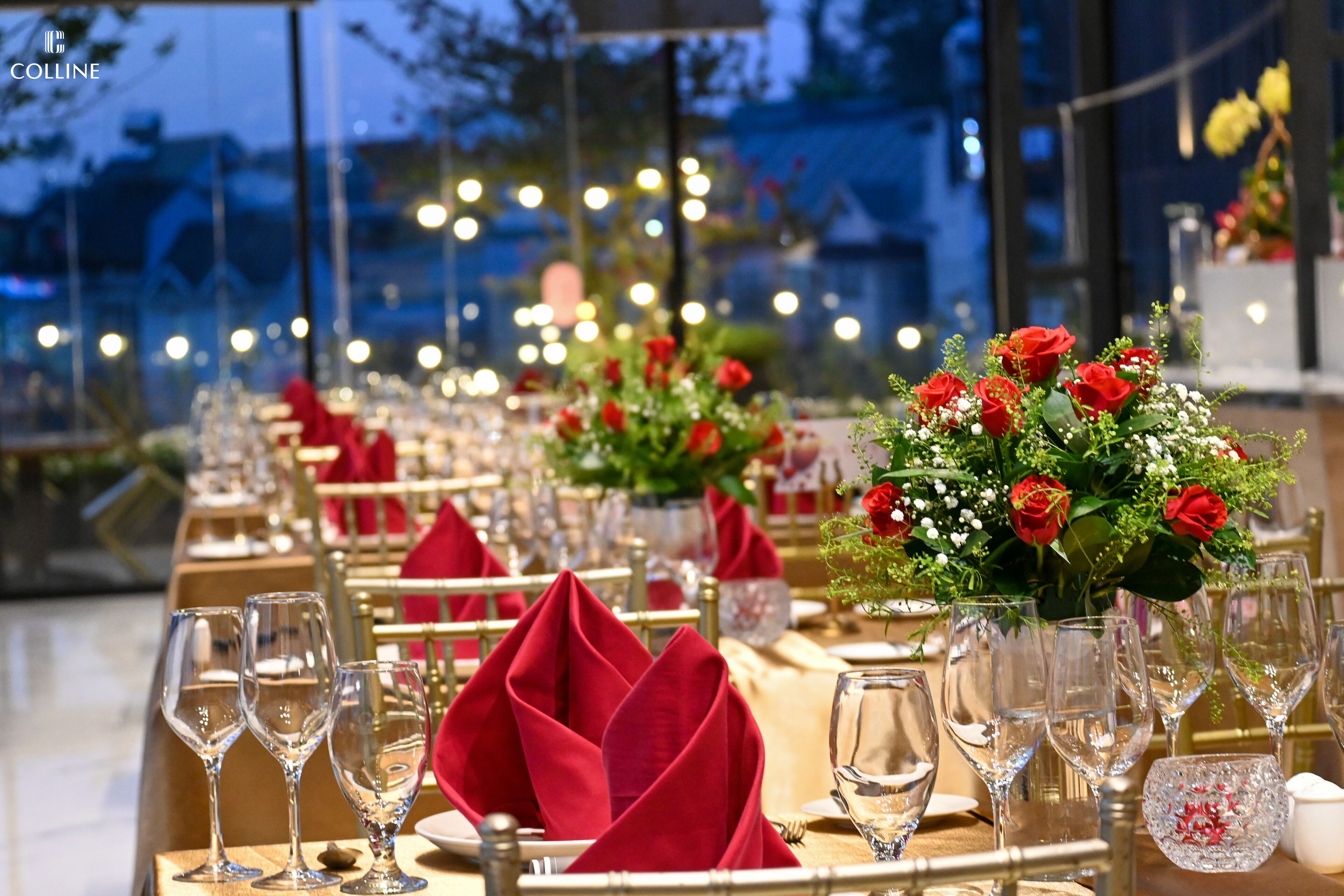 Una elegante mesa de comedor dispuesta para varios invitados, con servilletas rojas y cristalería transparente.