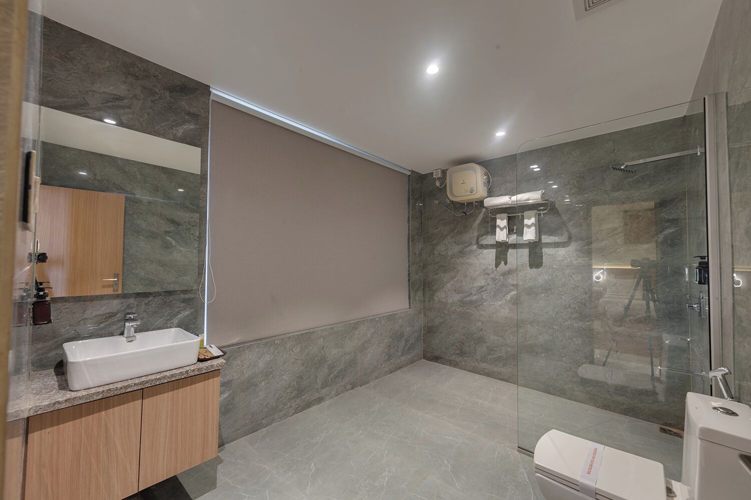 A modern bathroom with a glass shower enclosure, a sink, and a toilet.