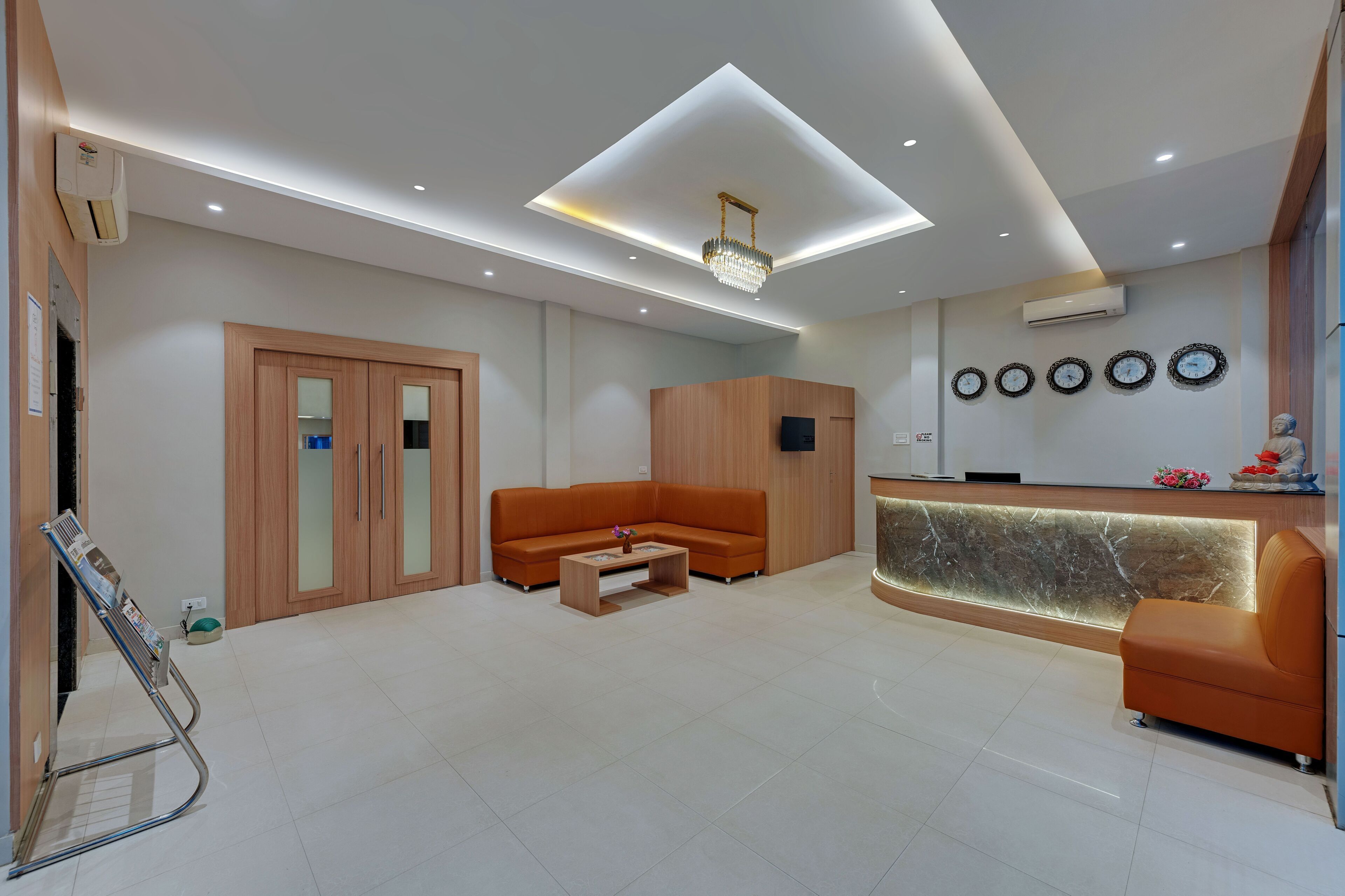 A modern reception area with a wooden reception desk, a sofa, and a coffee table.