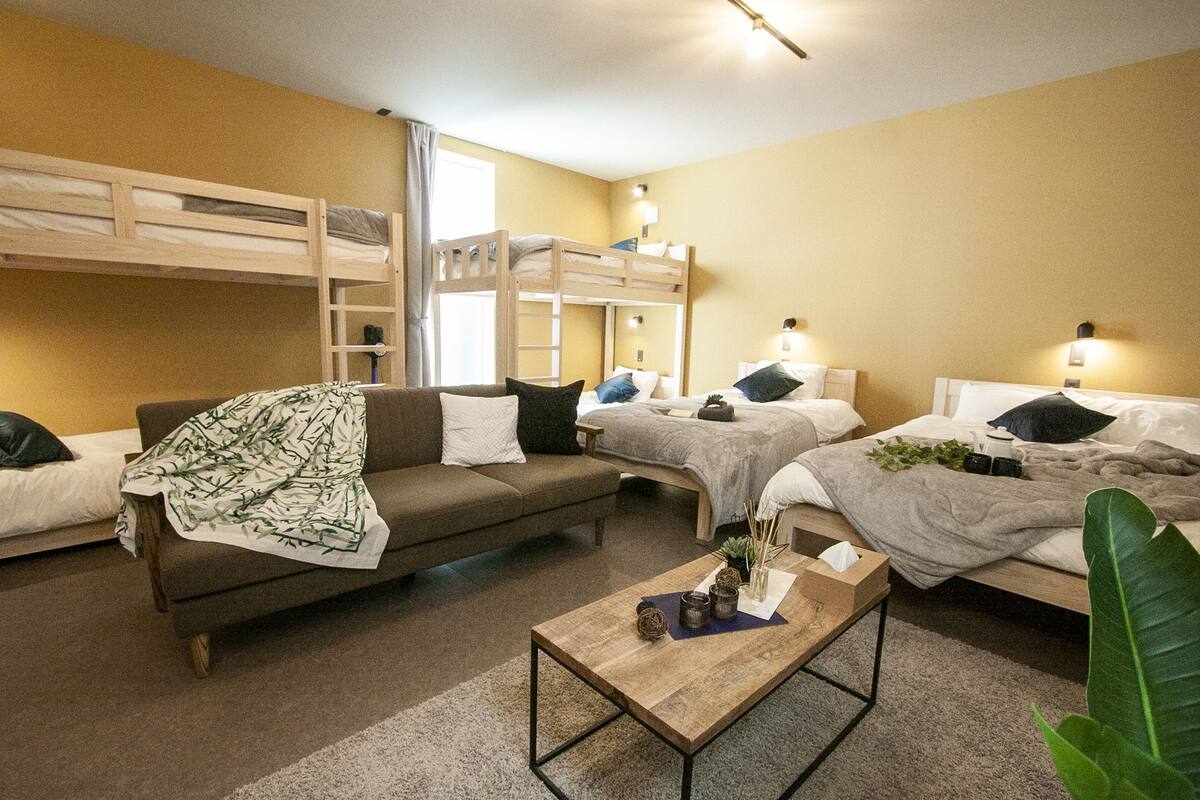 Une chambre avec des lits superposés, un canapé et une table basse.