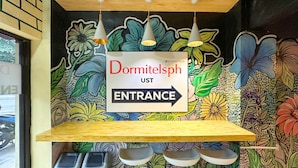 A colorful mural with a sign indicating the entrance to the dormitories. - Dormitelsph UST (Manila)
