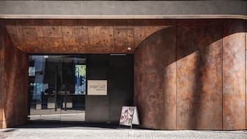 A modern building entrance with a large glass door, a sign reading "page 148", and a metal structure with a curved design.