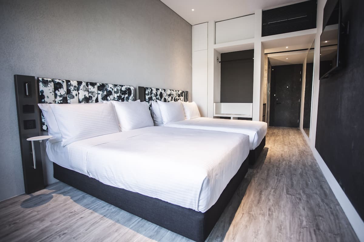 Un dormitorio moderno con una cama grande, una mesita de noche y un armario.