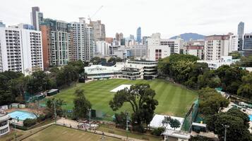 A large, open grassy area surrounded by high-rise buildings, likely a public park or sports field in an urban setting.