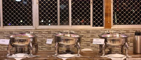 A buffet setup with labeled dishes including Puri, Zeera Rice, and Dal Makhani.