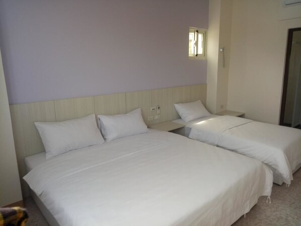 A hotel room with two single beds, a small window, and a door. - Taloan B&B (Beigan)