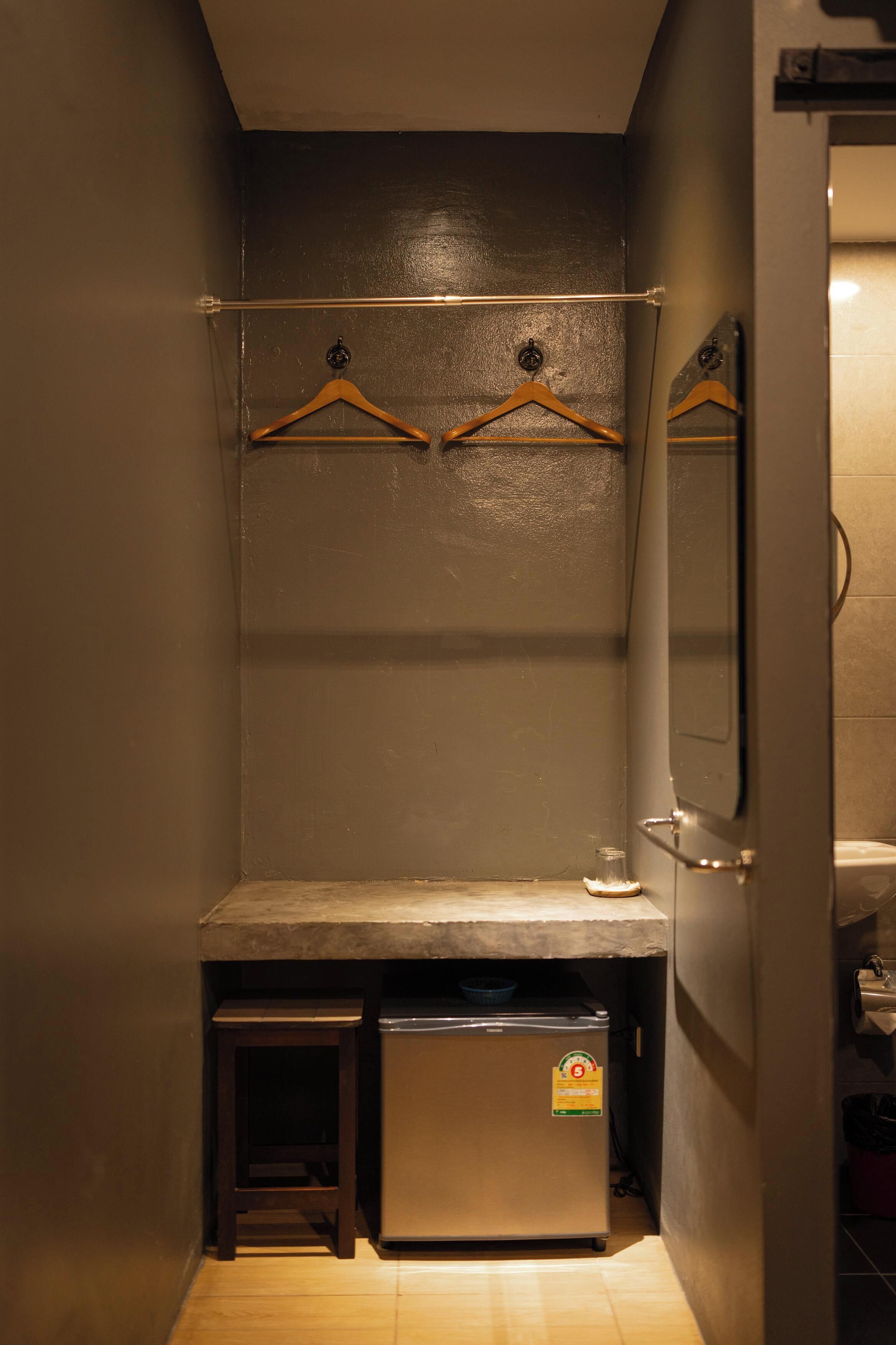 A compact bathroom with a small sink, a mirror, and a towel rack.