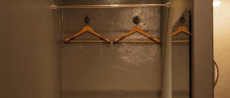 A compact bathroom with a small sink, a mirror, and a towel rack.