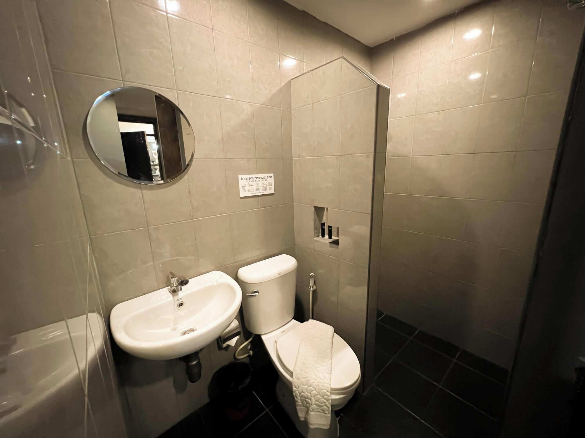 A bathroom with a sink, toilet, and a mirror.