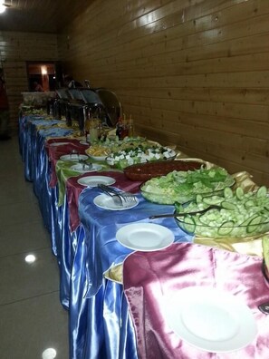 Una mesa de buffet con diversos alimentos y utensilios.
