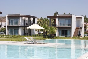 Una piscina al aire libre, sombrillas, tumbonas