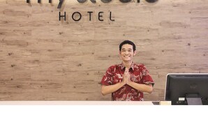 Een hotel receptiebalie met een houten achtergrond en de tekst 'my studio HOTEL' erboven.