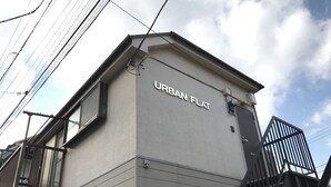 A building with the sign "URBAN FLAT" on its facade, featuring a modern design with a flat roof and a visible staircase. - Tokyo Urban Flat Hotel 201 (Tokyo)