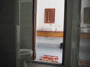Ein Badezimmer mit Toilette, Waschbecken und Duschbereich.
