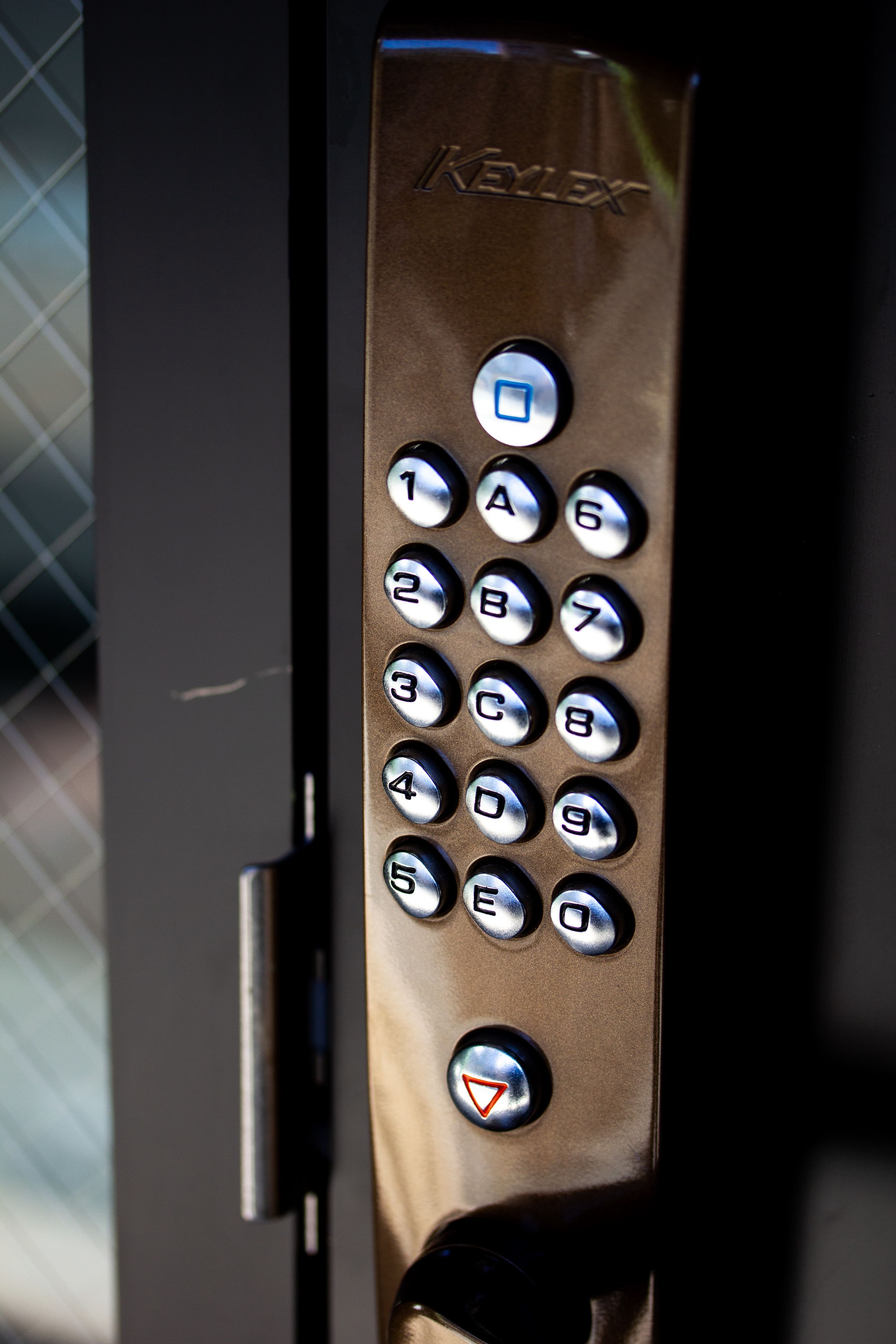 A keypad with the brand name "KEYEX" on a metallic surface.
