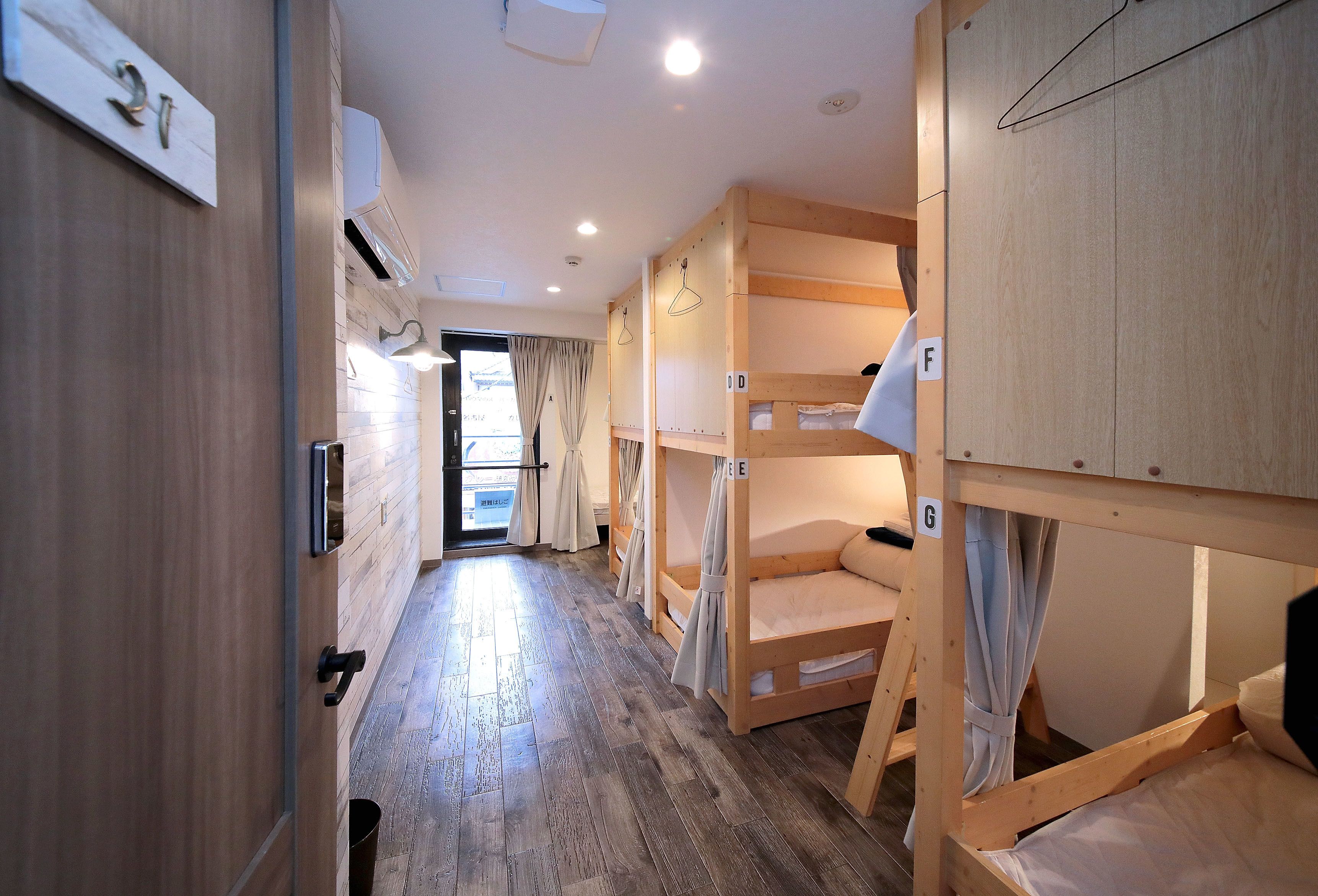 A corridor with bunk beds, wooden walls, and a number sign.