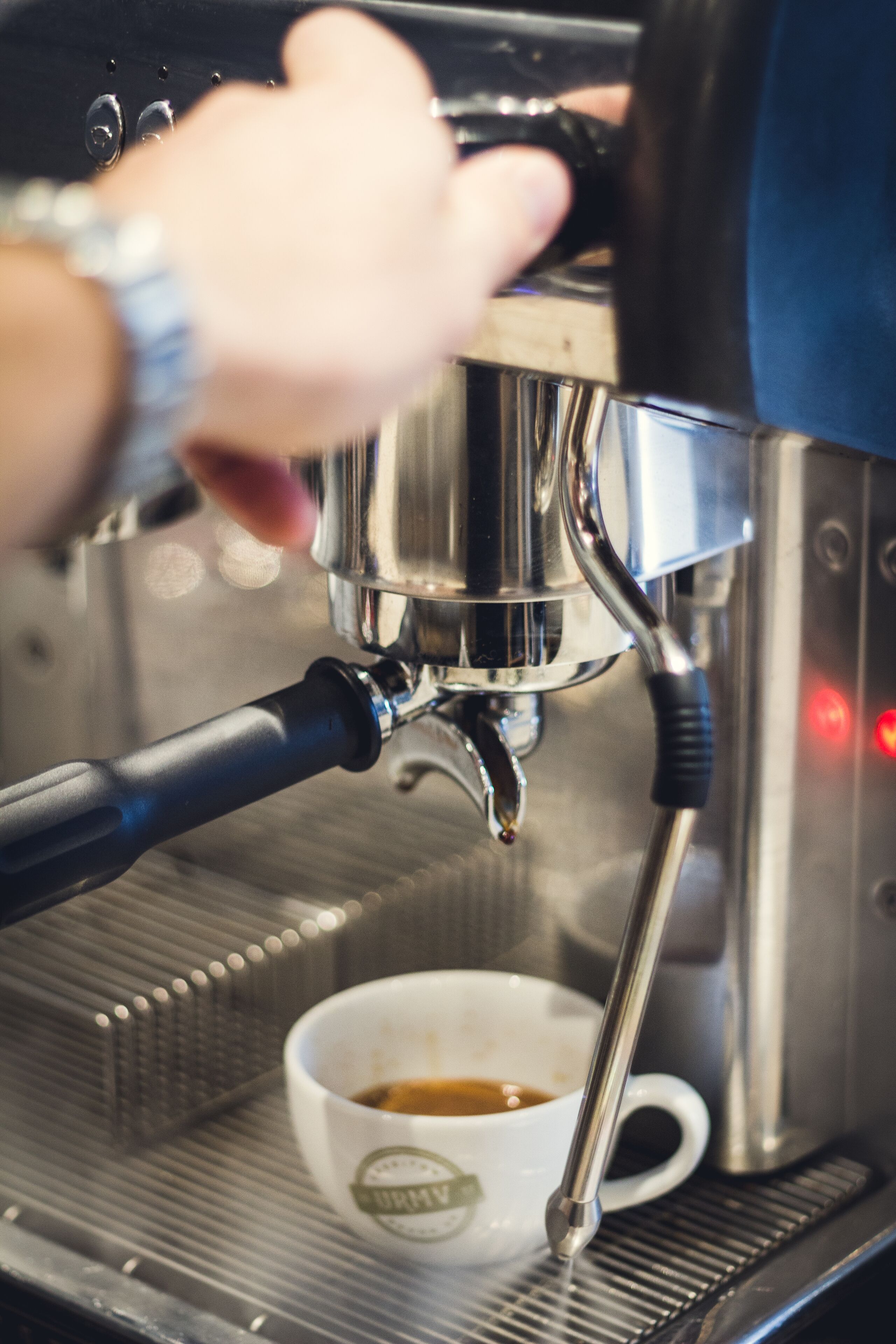 A close-up of a coffee machine dispensing coffee into a cup.
