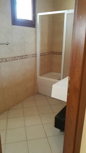 A bathroom with a shower, a bathtub, and a toilet.