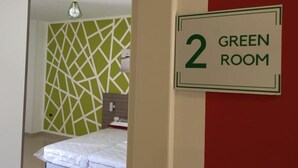 A room with a green geometric wall design, a bed with white bedding, and a sign indicating it is room number 2. - Bed & Breakfast Corso Roma (Apricena)