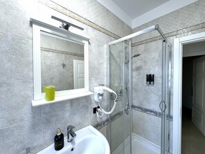 Quarto quádruplo luxo, para não fumantes | Banheiro | Chuveiro, produtos de toalete grátis, secador de cabelo, bidê