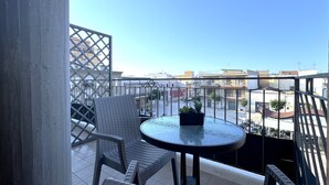 A balcony with a round table and two wicker chairs, overlooking a residential area with buildings and a clear sky. - Bed & Breakfast Corso Roma (Apricena)