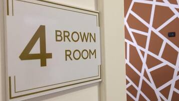 Señal que indica '4 BROWN ROOM' con un diseño geométrico en el fondo.