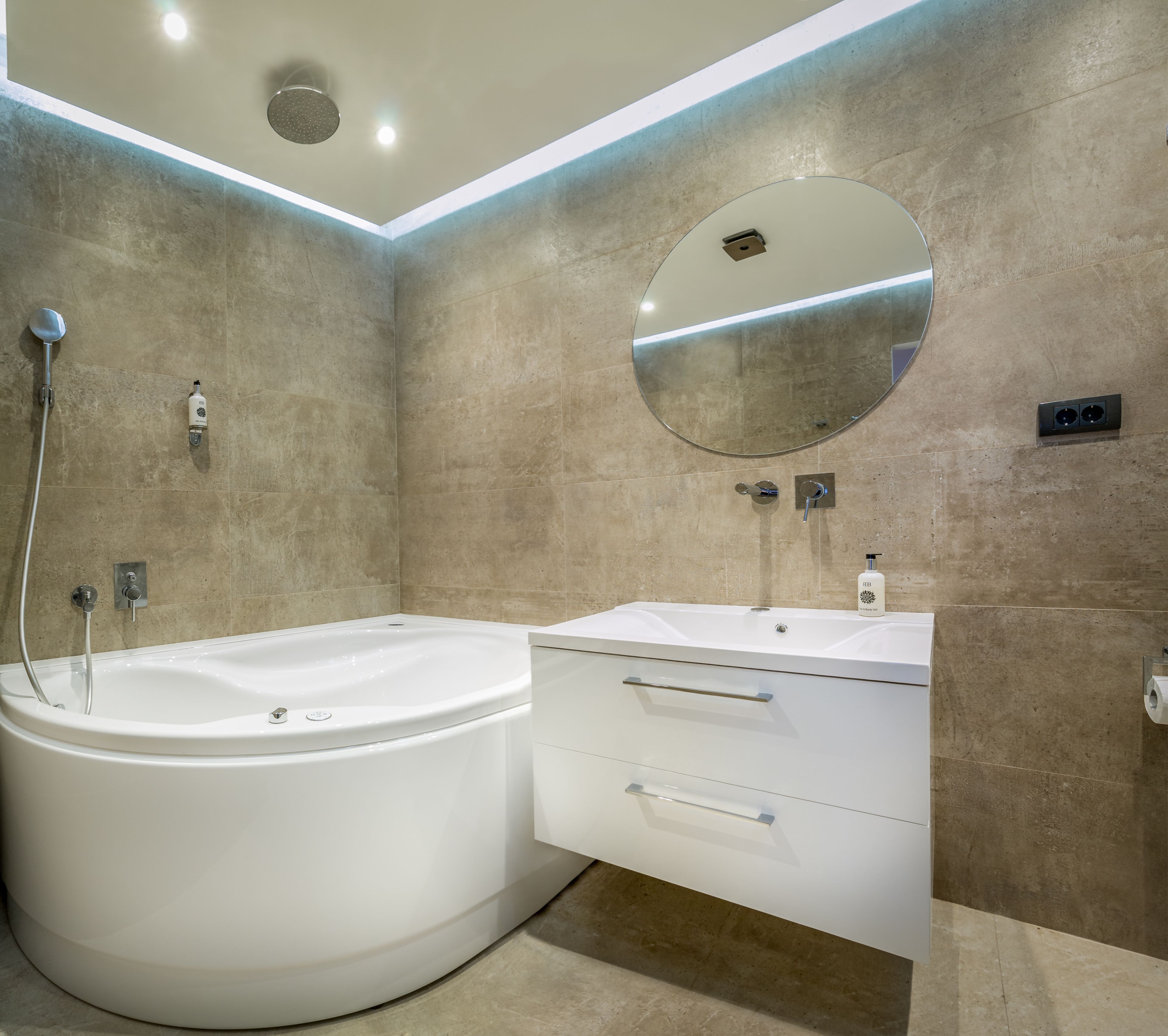 A modern bathroom with a freestanding bathtub, a vanity with a mirror, and a toilet.