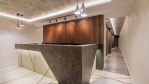 Un área de recepción con un mostrador grande y moderno y un revestimiento de pared de madera.