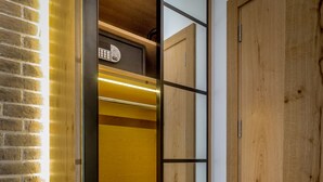 Un armario de madera con puerta espejada, una pared de ladrillo y un suelo de madera.
