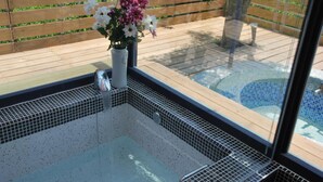 A hot tub with a tiled interior and a wooden deck outside. - Lotus Hostel Beicheng Zhuang (Luodong)