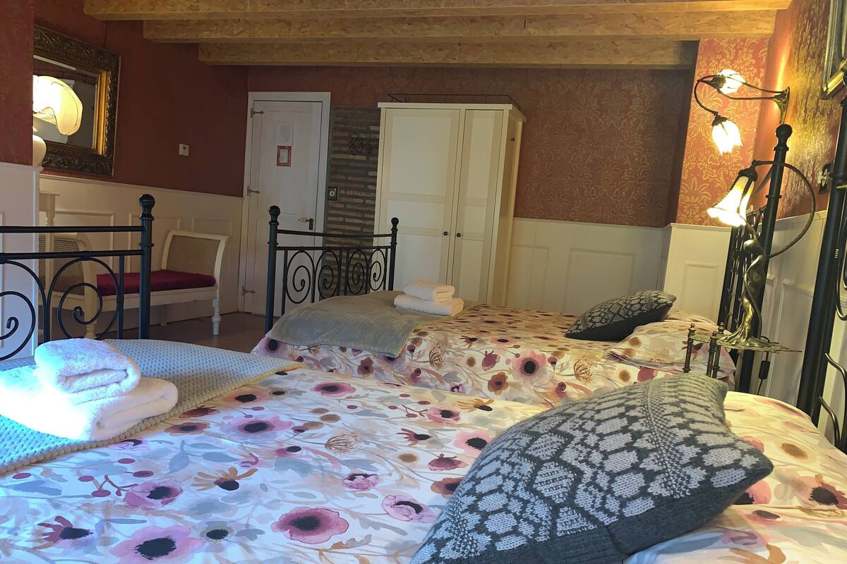 Quarto com cama, cadeira, guarda-roupa e espelho.
