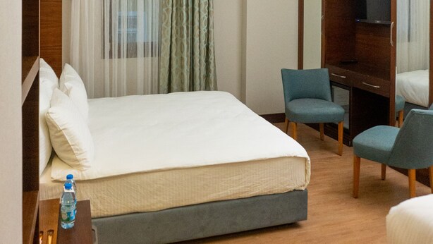 A hotel room with a bed, a desk, a chair, and a television. - Long Stay İstanbul Hotel (Istanbul)
