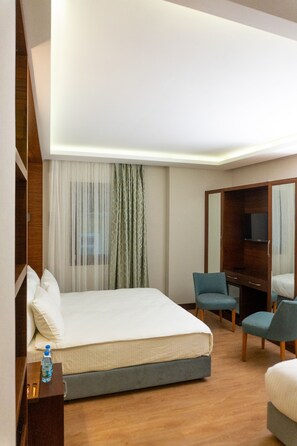 A hotel room with a bed, a desk, a chair, and a television. - Long Stay İstanbul Hotel (Istanbul)